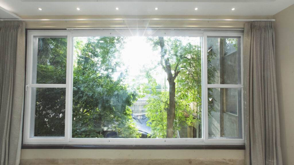 A room with a large window and curtains.