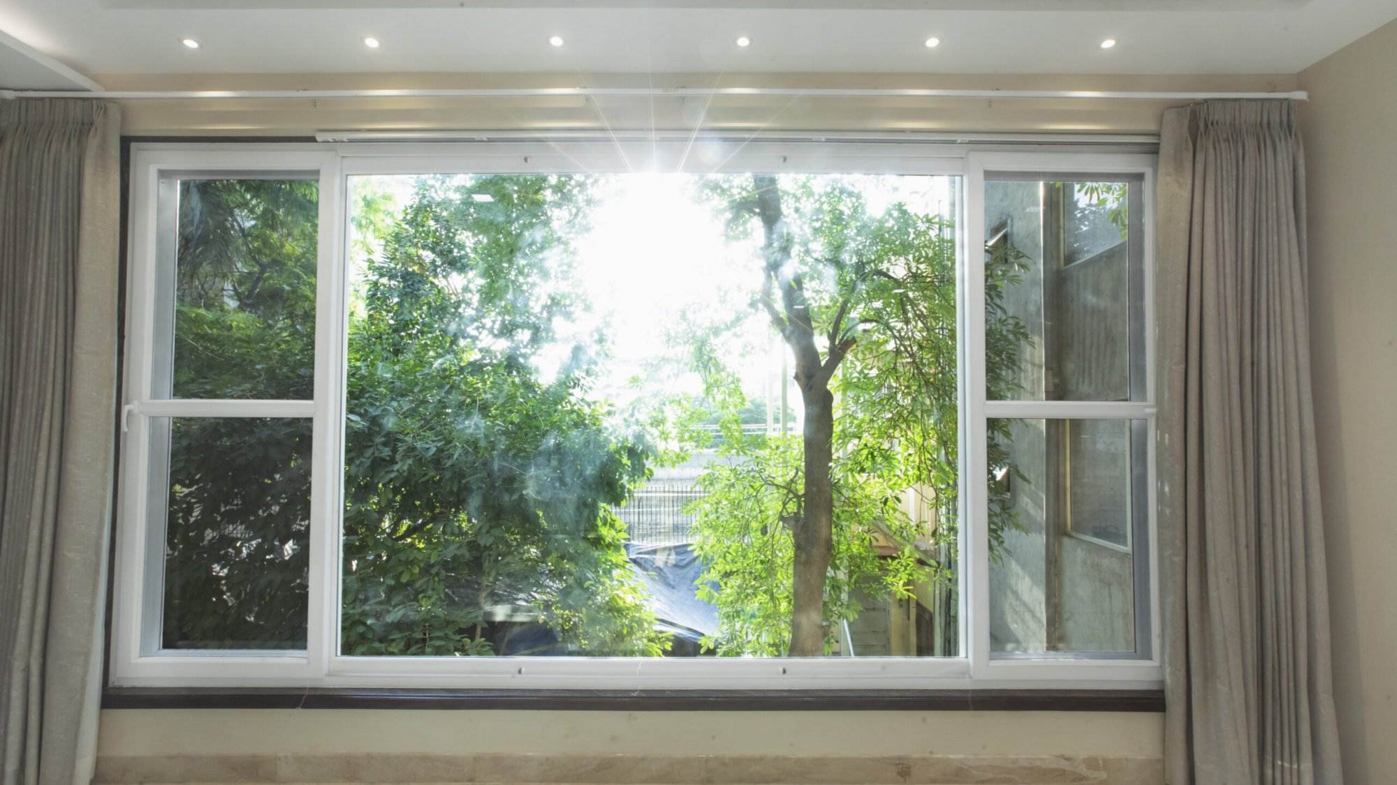 A room with a large window and curtains.