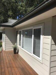A house with a wooden deck, white siding, and UPVC casement windows.