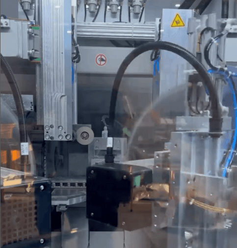 Introducing the SBA-2 CNC Profile Processing Centre 1 Automated industrial machinery, including CNC profile processing equipment, operates with robotic arms and various cables in a factory environment.