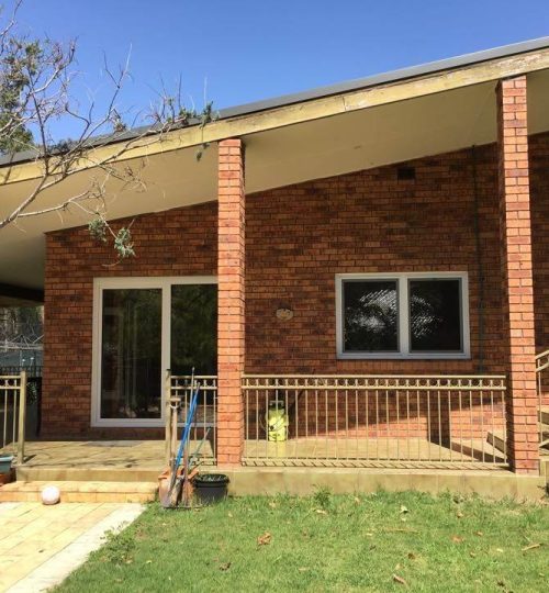 A house with a brick patio and a wooden deck.