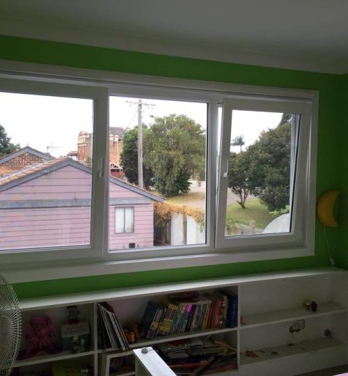 A child's room with green walls and a window.