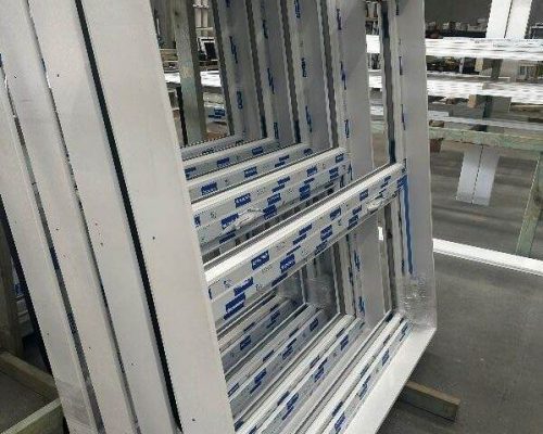 A group of white window frames in a warehouse. A group of white window frames in a warehouse.