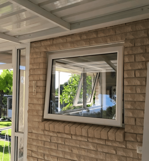 A porch with a window and a brick wall.