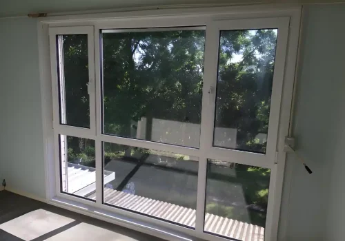A room with a sliding UPVC glass door and a wooden floor.