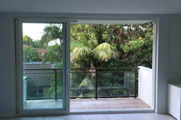 An empty living room with a sliding glass door.