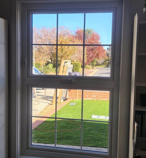 UPVC Casement & Awning Windows 3 A white UPVC casement window in a room with a grassy yard.