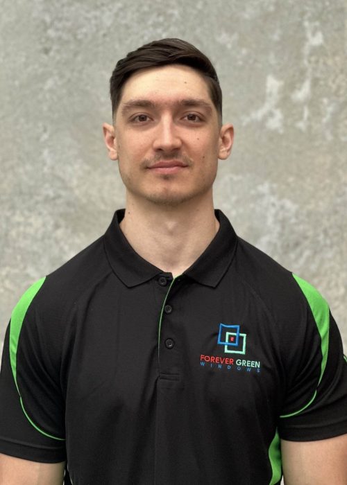 A man wearing a black and green polo shirt.