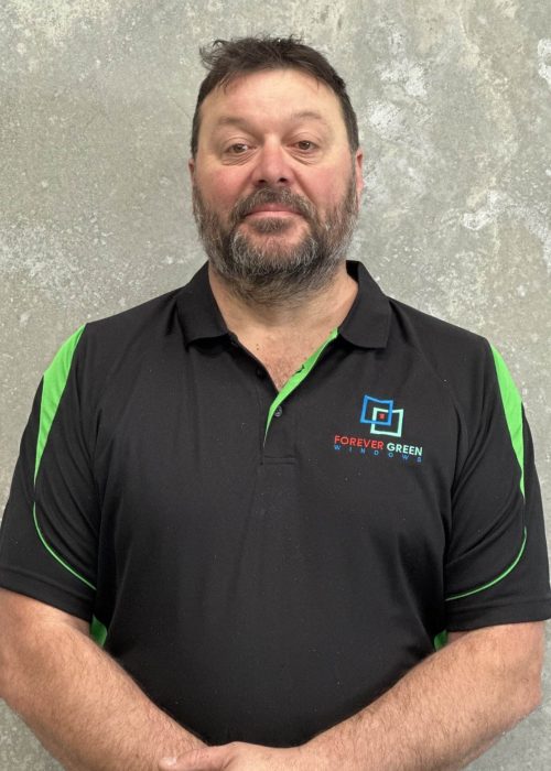 A man wearing a black and green polo shirt.